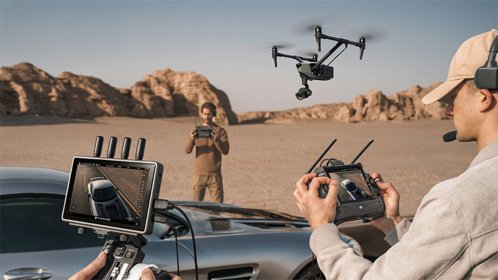 Drone applications filming a car in the desert using professional aerial cinematography equipment.