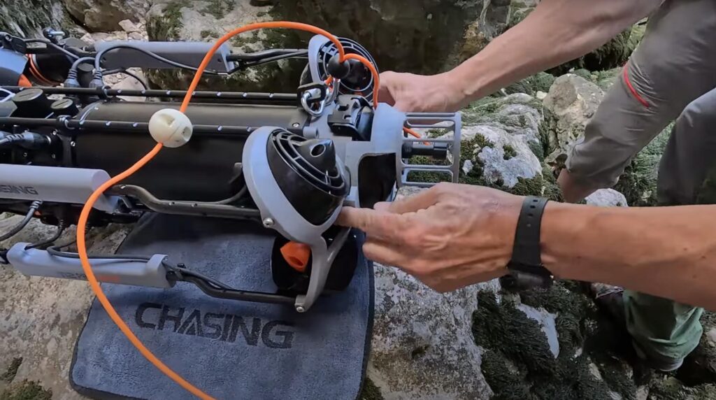 Person holding the Chasing M2 PRO MAX Standard underwater drone remote controller during outdoor setup