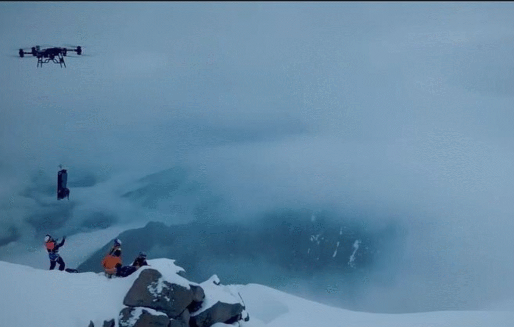 Cargo drone flying over snowy mountain ridges, delivering supplies as part of drone mountain logistics operations.