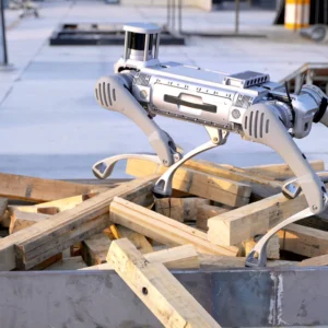 The B2-XF2-F quadruped robot dog demonstrating its balancing capabilities by walking across an uneven pile of wooden planks in an industrial testing yard